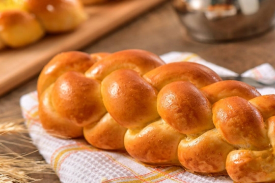 Cinnamon apple challah on a white and red striped cloth